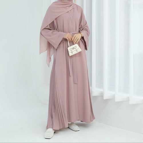 Woman wearing a pink abaya in a white room