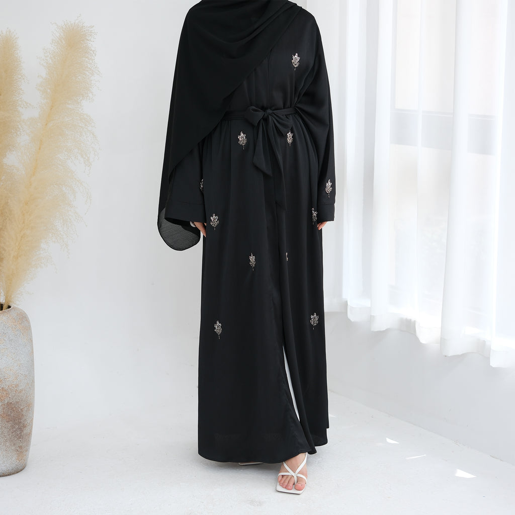 Black abaya with floral embroidery on a white background. Abaya_Awrak_Al-Anaaqa_Back- Noor & Grace
