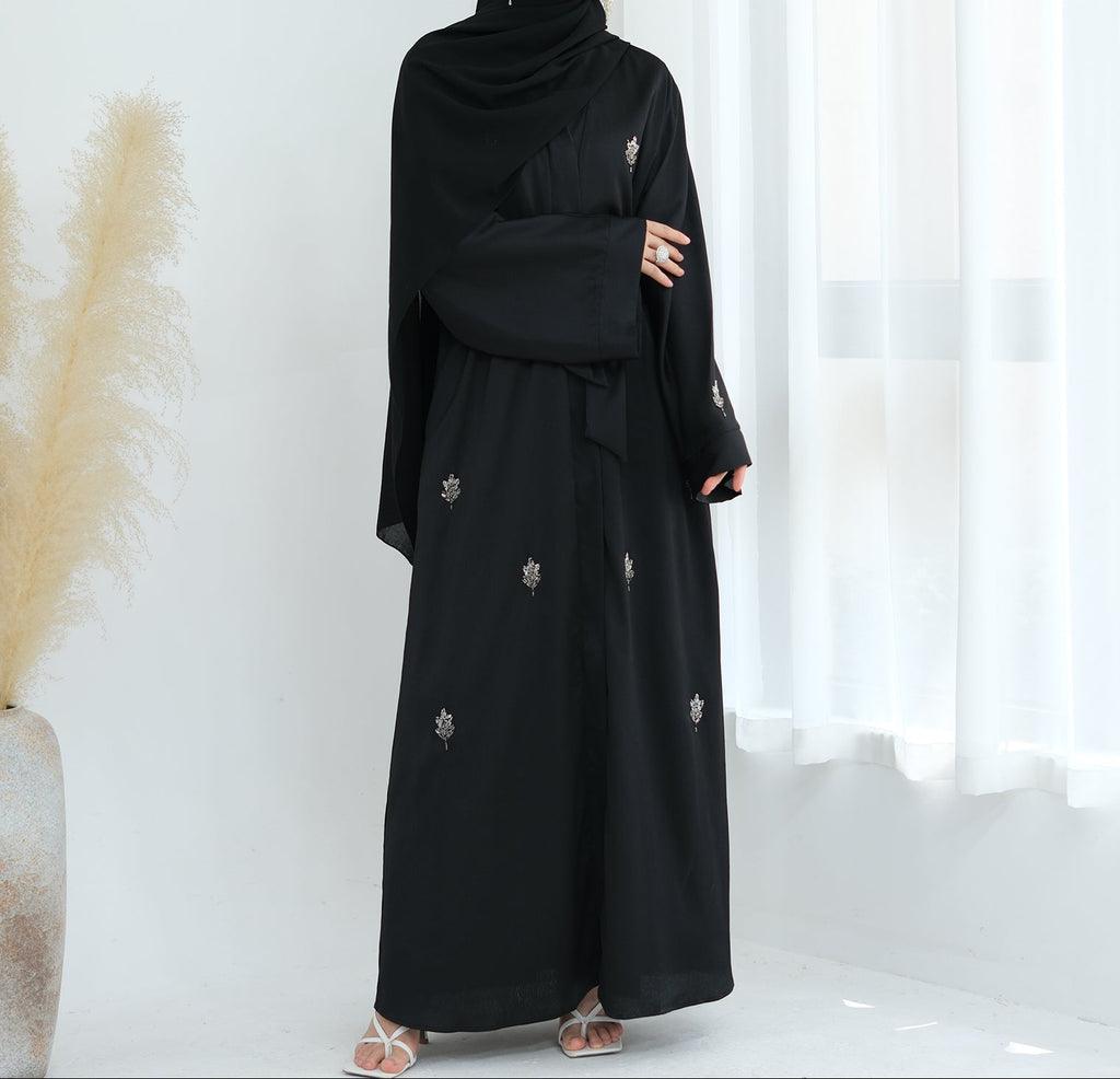 Black abaya with floral embroidery on a white background. Abaya_Awrak_Al-Anaaqa_Back- Noor & Grace