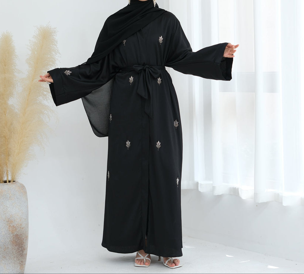Black abaya with floral embroidery on a white background. Abaya_Awrak_Al-Anaaqa_Back- Noor & Grace