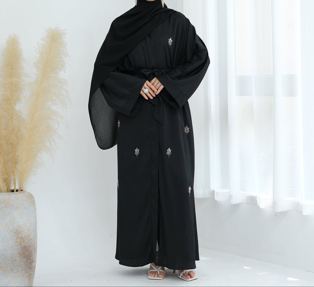 Black abaya with floral embroidery on a white background. Abaya_Awrak_Al-Anaaqa_Back- Noor & Grace