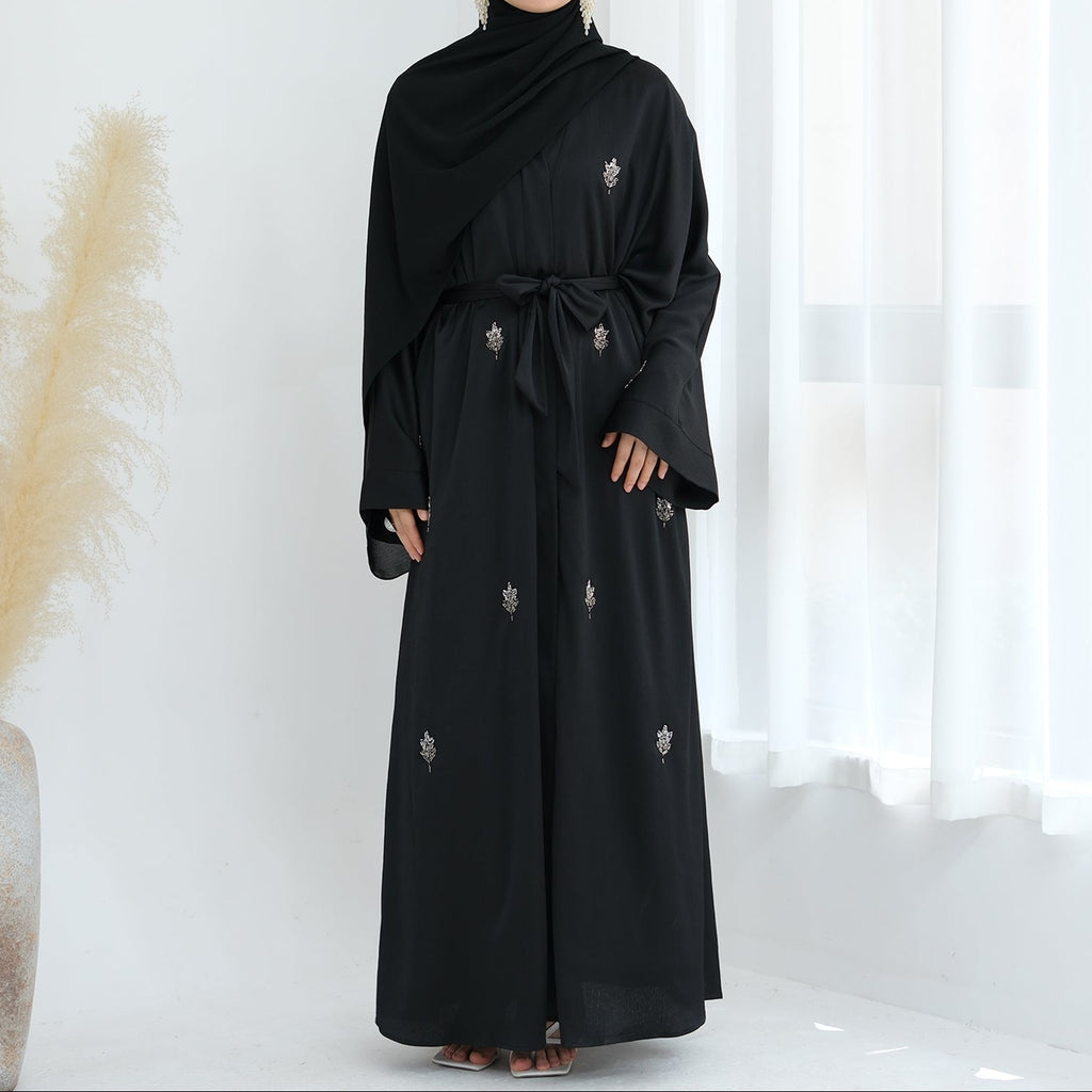 Black abaya with floral embroidery on a white background. Abaya_Awrak_Al-Anaaqa_Back- Noor & Grace