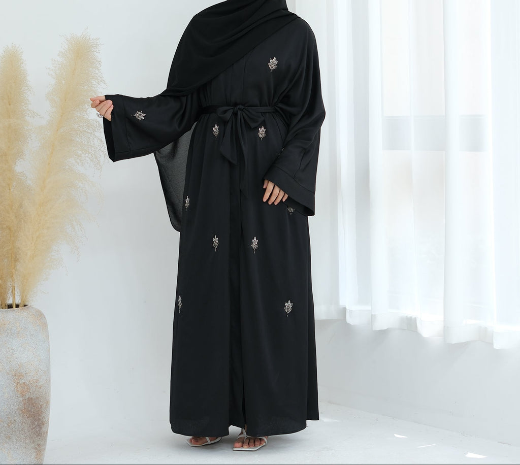 Black abaya with floral embroidery on a white background. Abaya_Awrak_Al-Anaaqa_Back- Noor & Grace