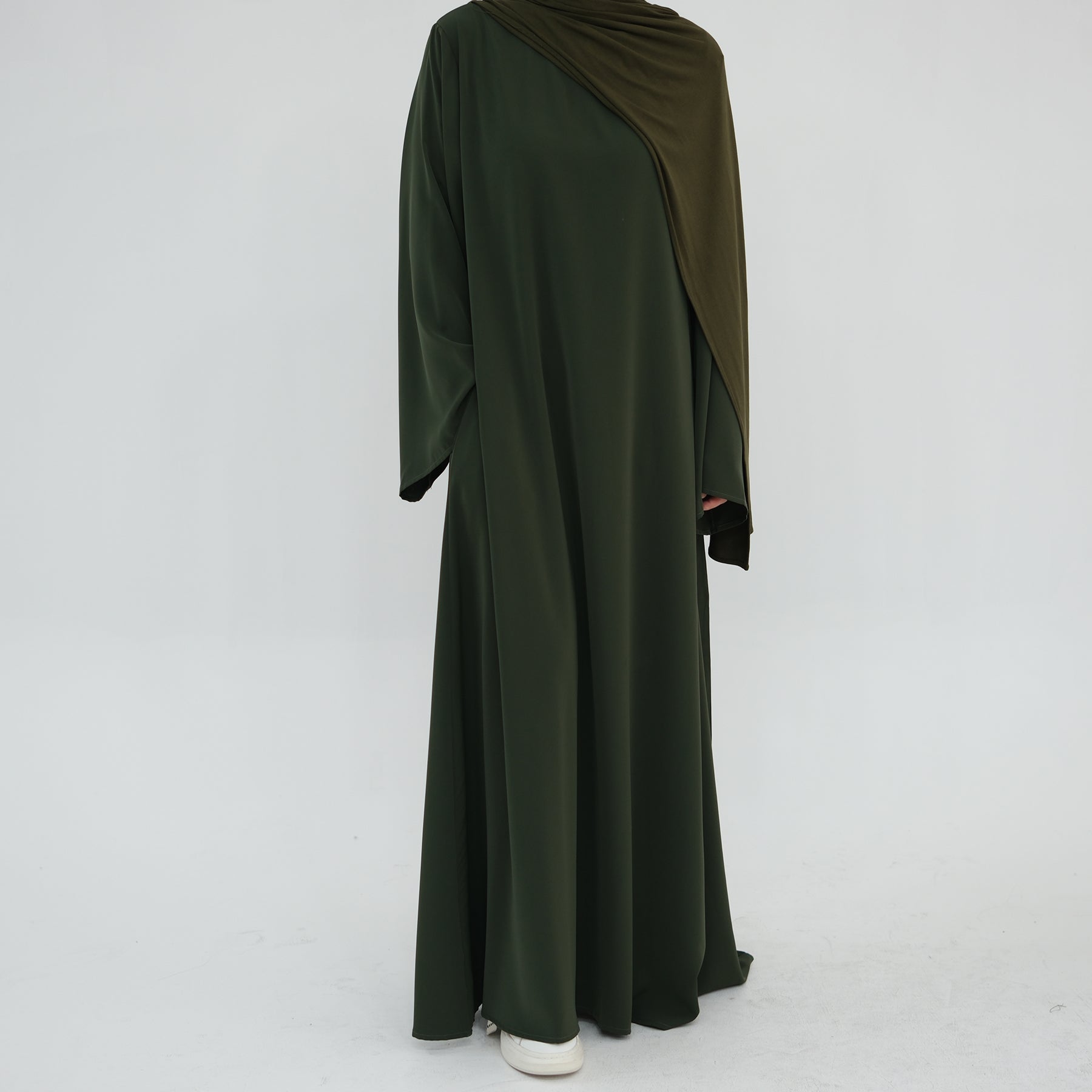 Green abaya with brown hood on a white background