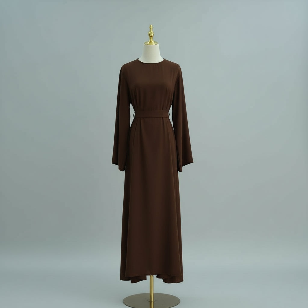 Brown dress on a mannequin against a gray background. AsasAbayaInnerDress_Noor_Grace Coffee - Noor & Grace