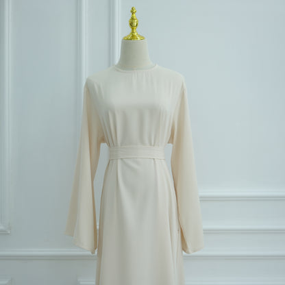 Beige dress on a mannequin against a white wall. AsasAbayaInnerDress_Noor_Grace Beige - Noor & Grace