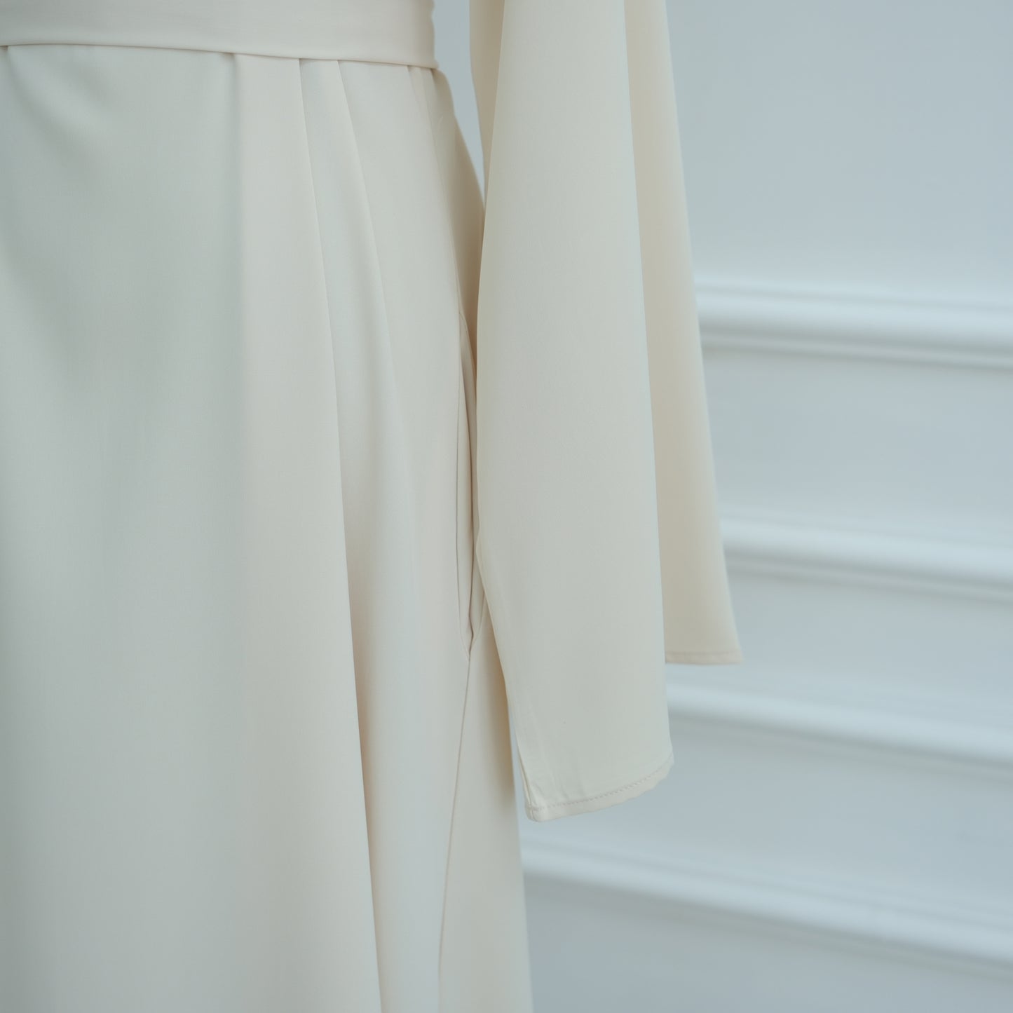 Close-up of beige pants with a blurred background. AsasAbayaInnerDress_Noor_Grace Beige - Noor & Grace