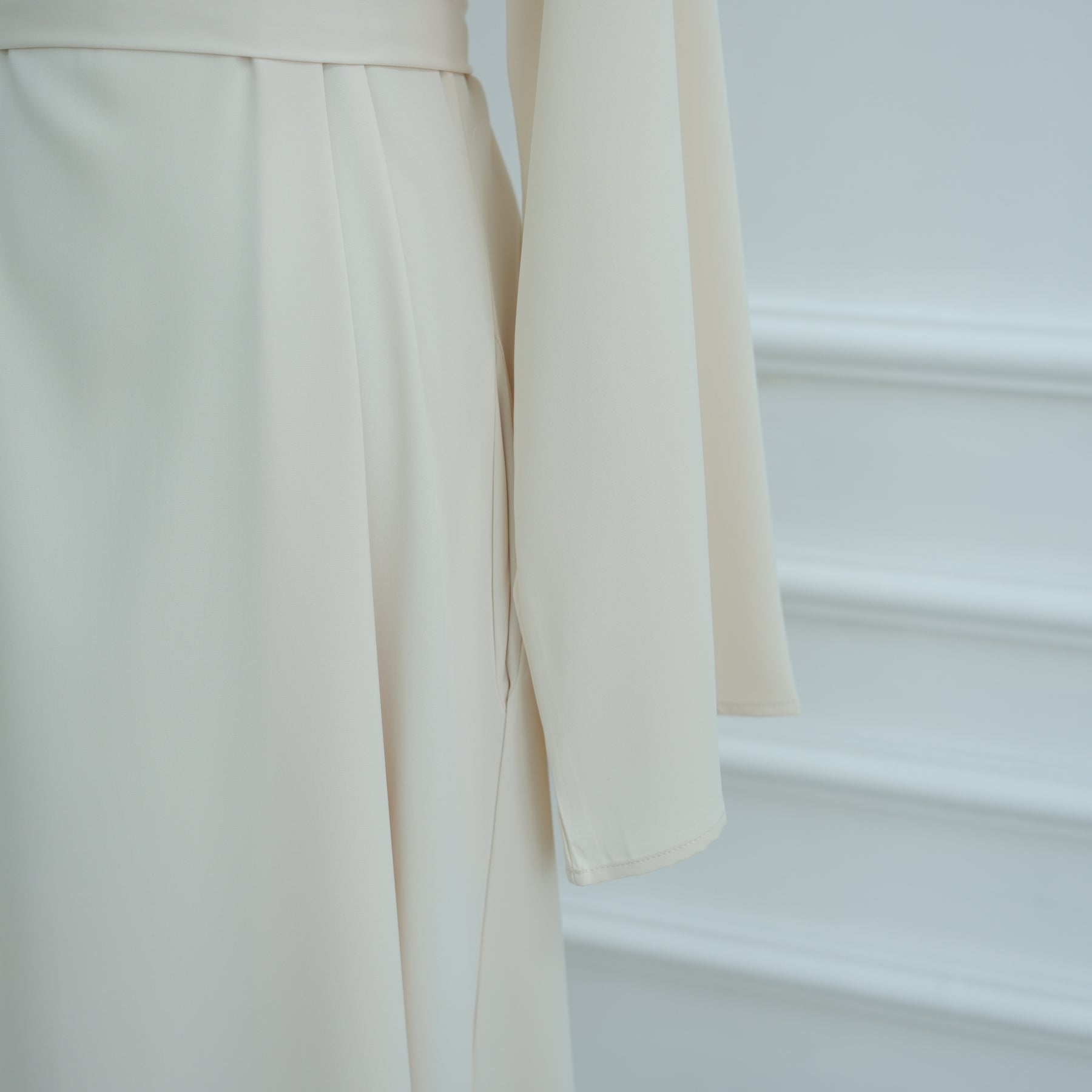 Close-up of beige pants with a blurred background. AsasAbayaInnerDress_Noor_Grace Beige - Noor & Grace