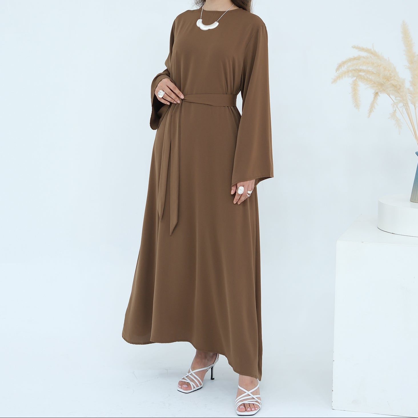 Woman wearing a brown dress on a white background