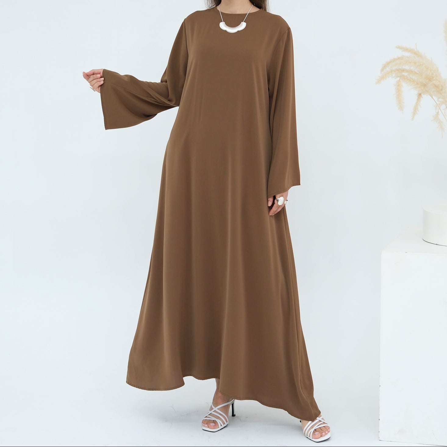 Woman wearing a brown dress on a white background