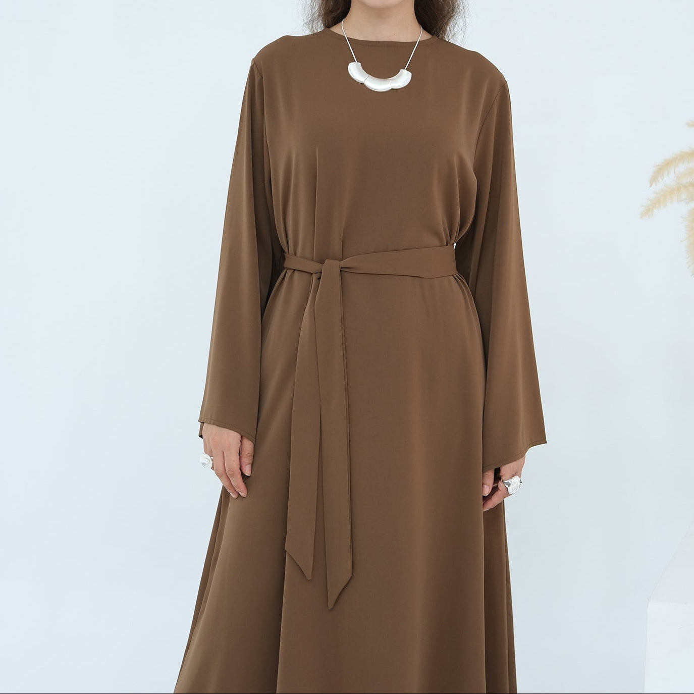 Woman wearing a brown dress with a white background