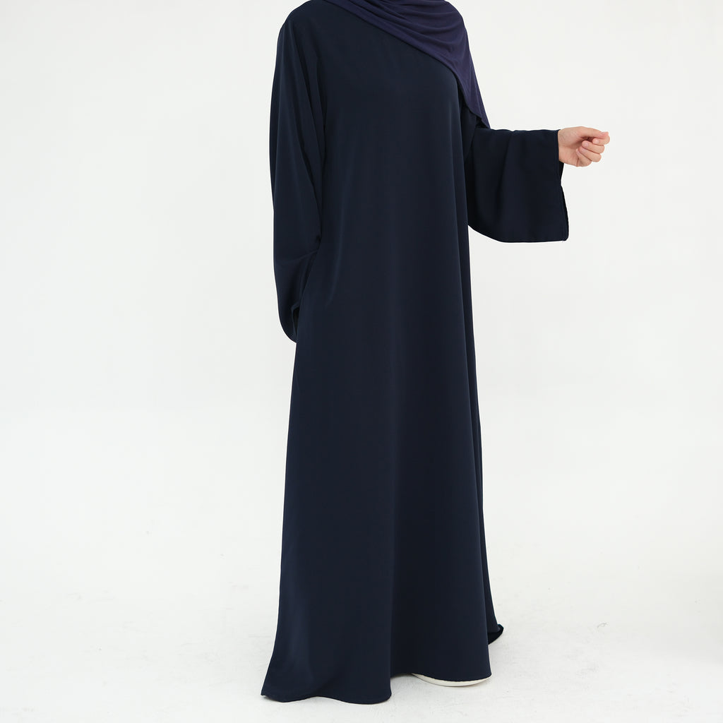 Navy blue abaya worn by a person on a white background