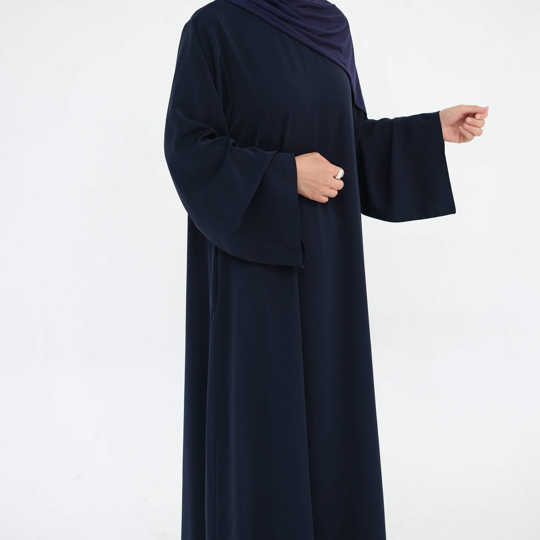 Navy blue abaya worn by a person on a white background