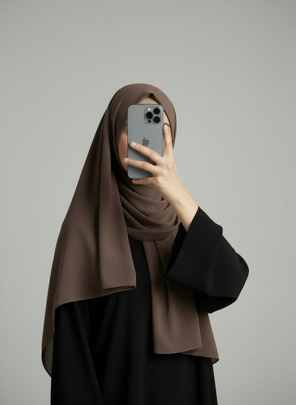 Brown chiffon hijab on a model with a plain gray background. Brown_Chiffon_Hijab Noor& Grace