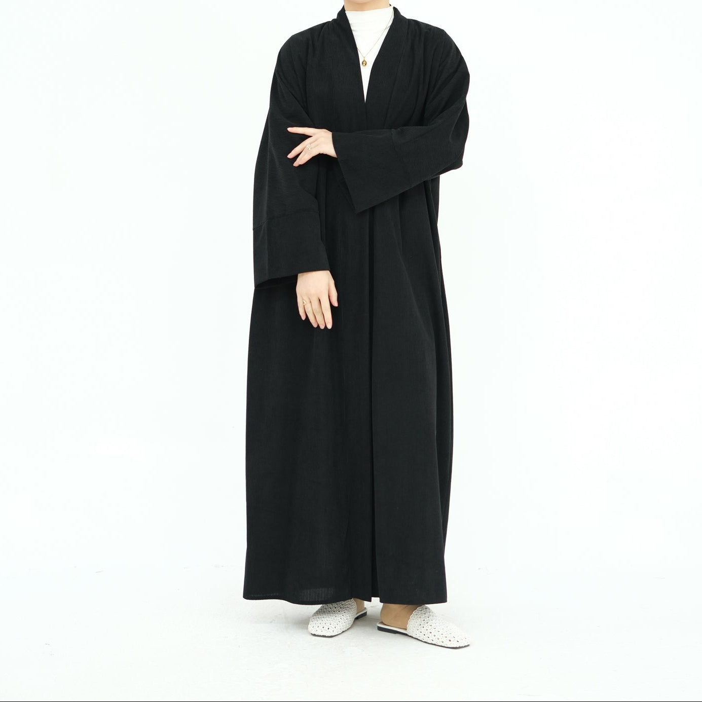 Woman wearing a black abaya on a white background. ClassicCorduroyAbaya_Black1 - Noor & Grace