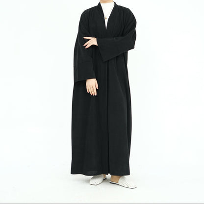 Woman wearing a black abaya on a white background. ClassicCorduroyAbaya_Black1 - Noor & Grace