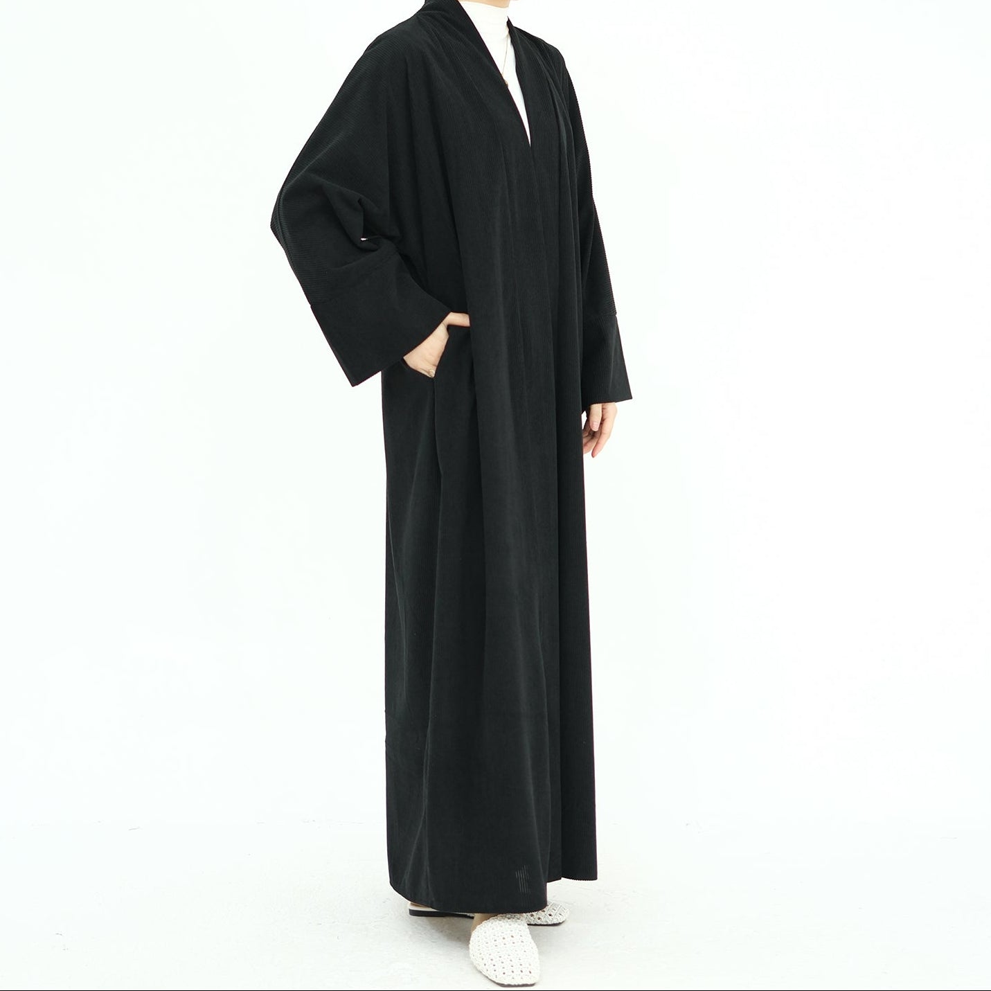 Woman wearing a black abaya on a white background. ClassicCorduroyAbaya_Black1 - Noor & Grace