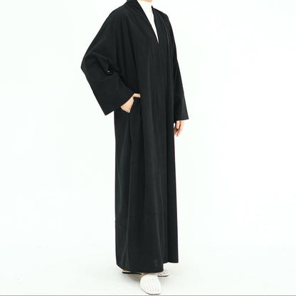 Woman wearing a black abaya on a white background. ClassicCorduroyAbaya_Black1 - Noor & Grace