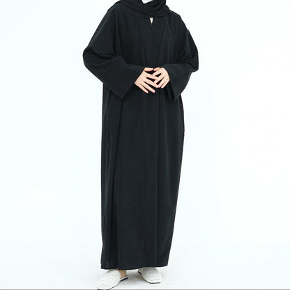 Woman wearing a black abaya on a white background. ClassicCorduroyAbaya_Black1 - Noor & Grace