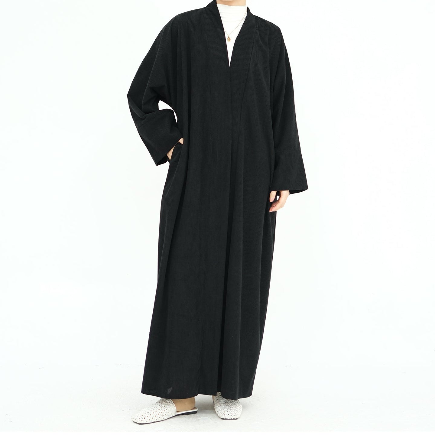 Woman wearing a black abaya on a white background. ClassicCorduroyAbaya_Black1 - Noor & Grace