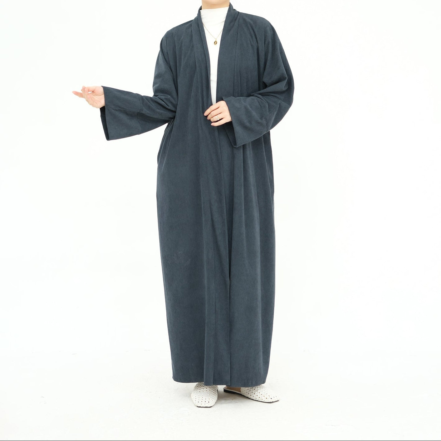 Woman wearing a long dark gray abaya with a beige hijab on a white background. ClassicCorduroyAbaya_Gray2 - Noor & Grace