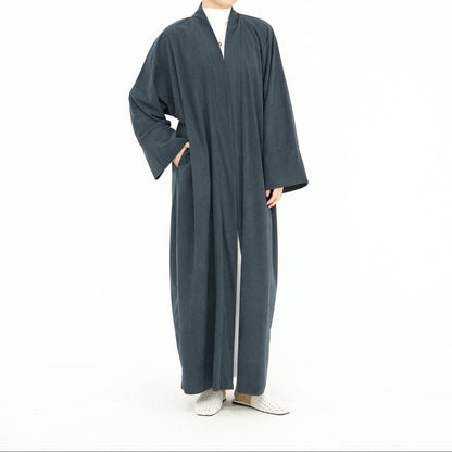 Woman wearing a long dark gray abaya with a beige hijab on a white background. ClassicCorduroyAbaya_Gray2 - Noor & Grace