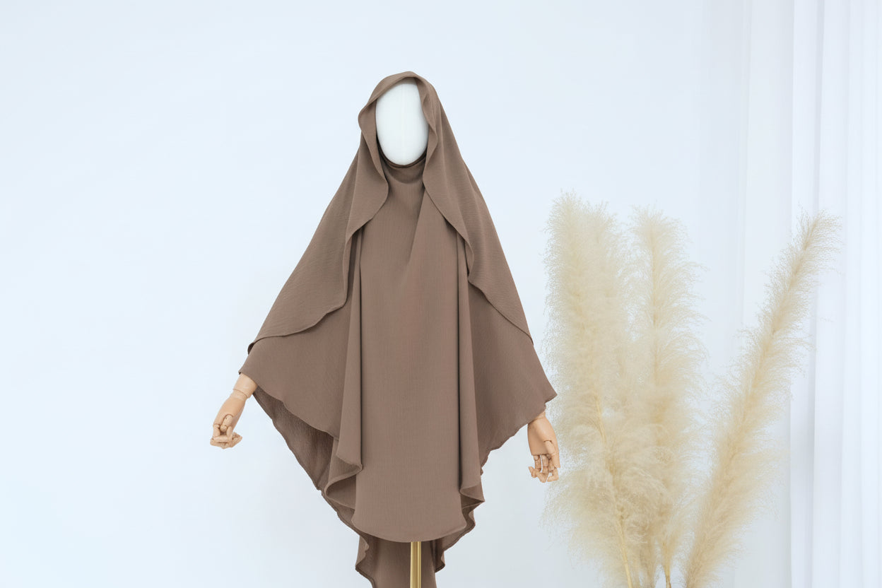 Brown hijab on a mannequin with decorative elements on a light background