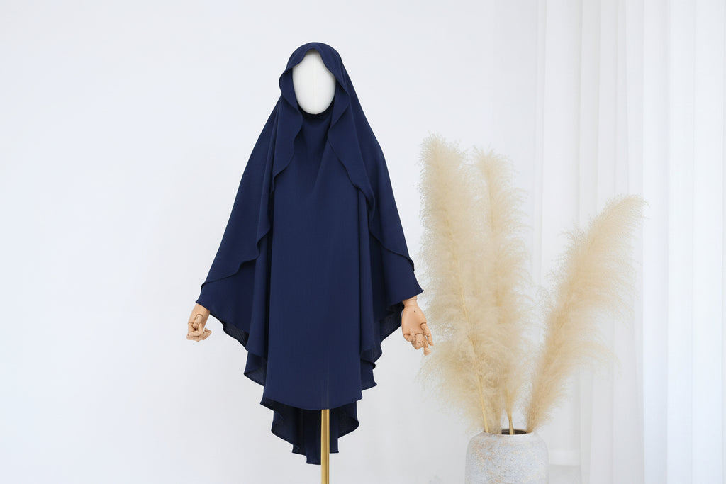 Blue hijab on a mannequin against a white background with pampas grass.