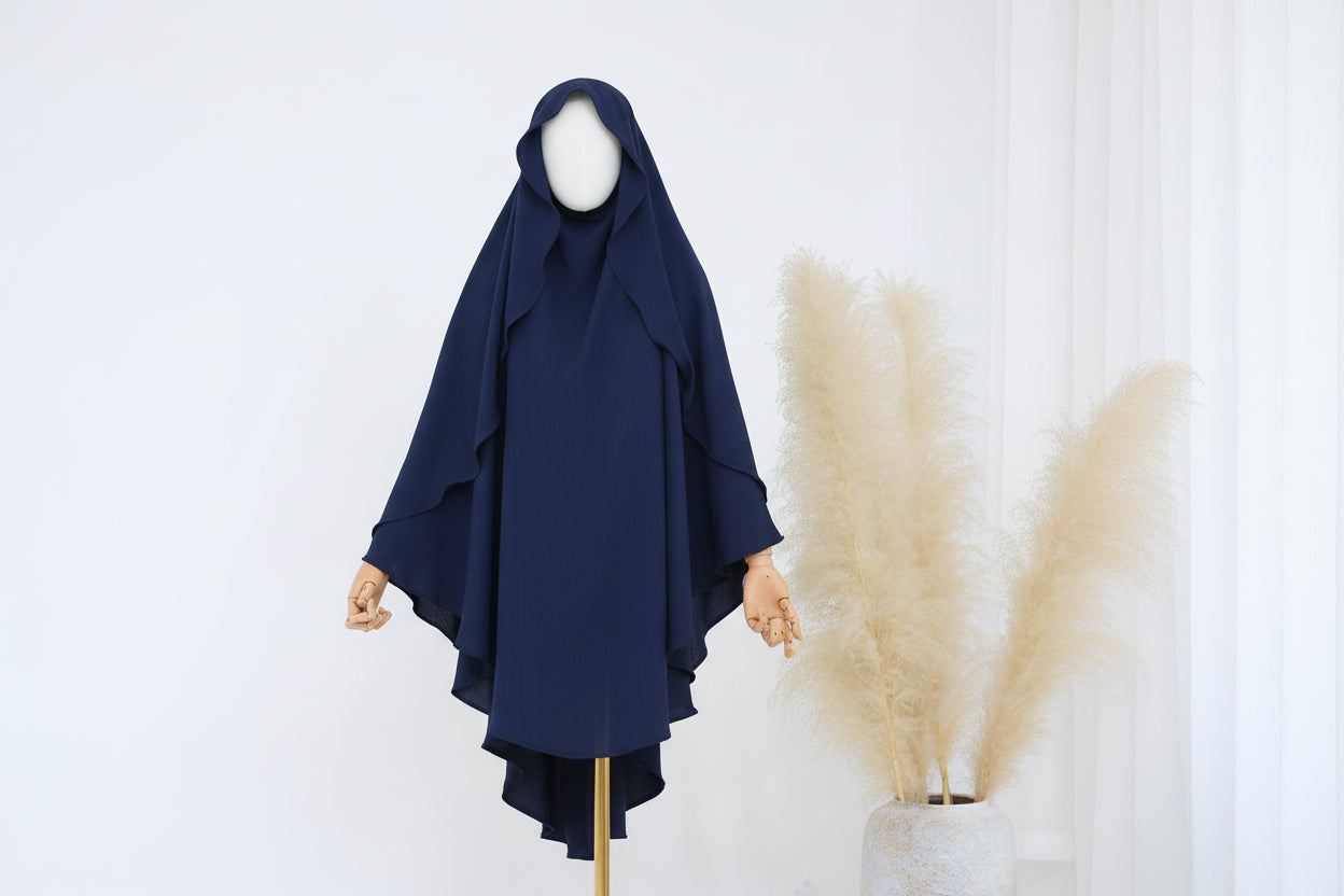 Blue hijab on a mannequin against a white background with pampas grass.