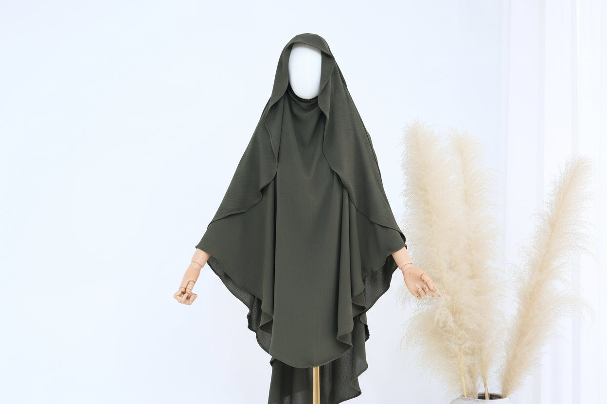 Green hijab on a mannequin with a white background and pampas grass decoration.