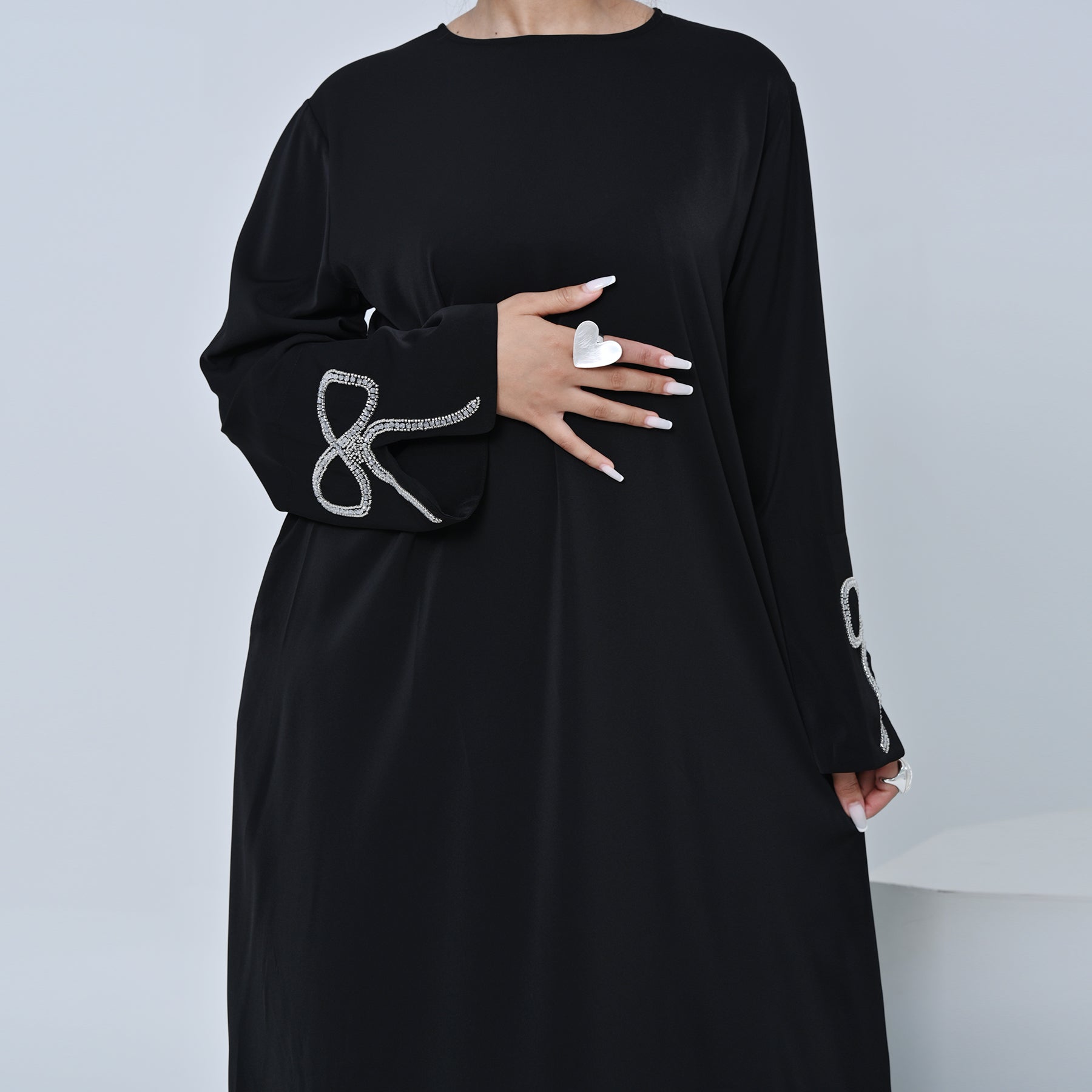 Black dress with decorative sleeves on a plain background