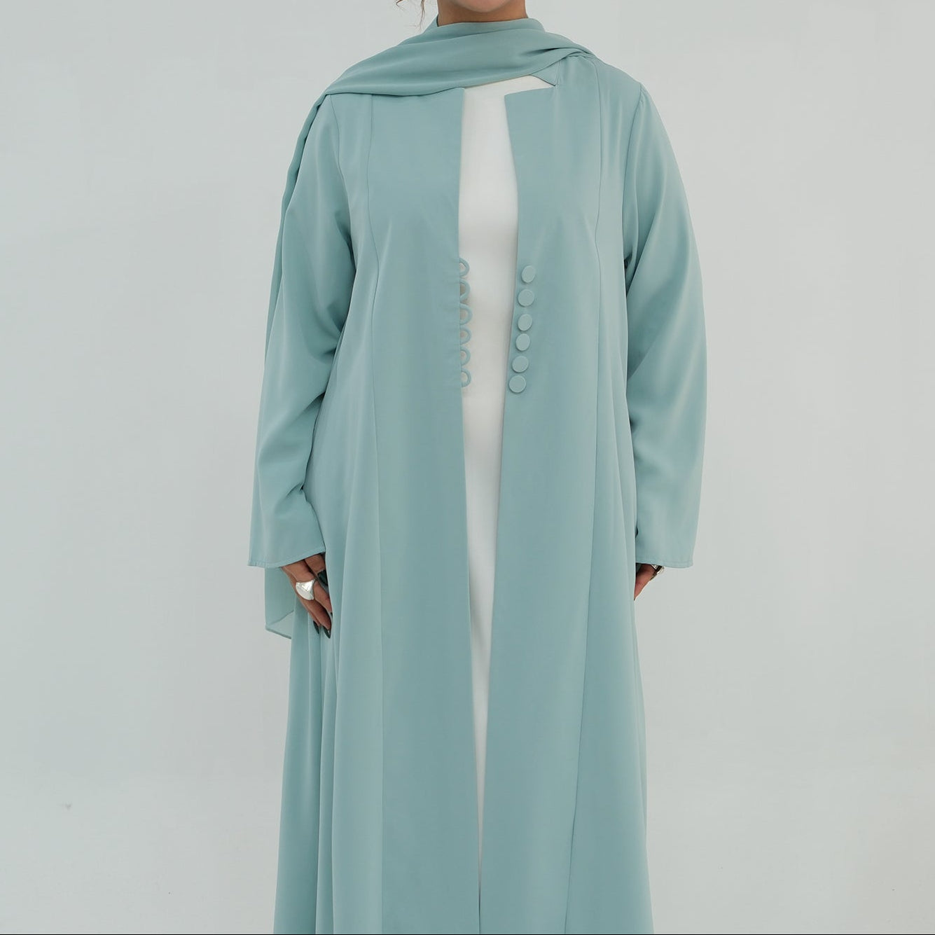 Woman wearing a light blue abaya on a white background