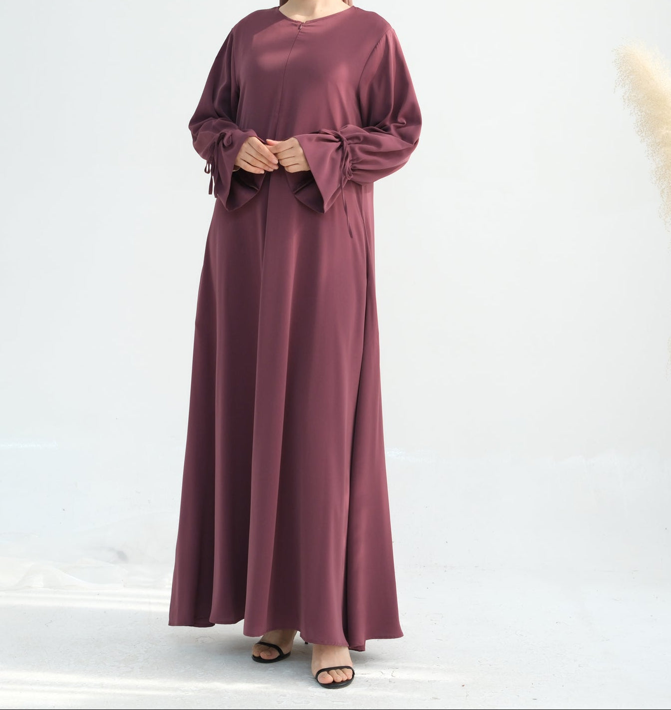 Woman wearing a long burgundy dress on a white background