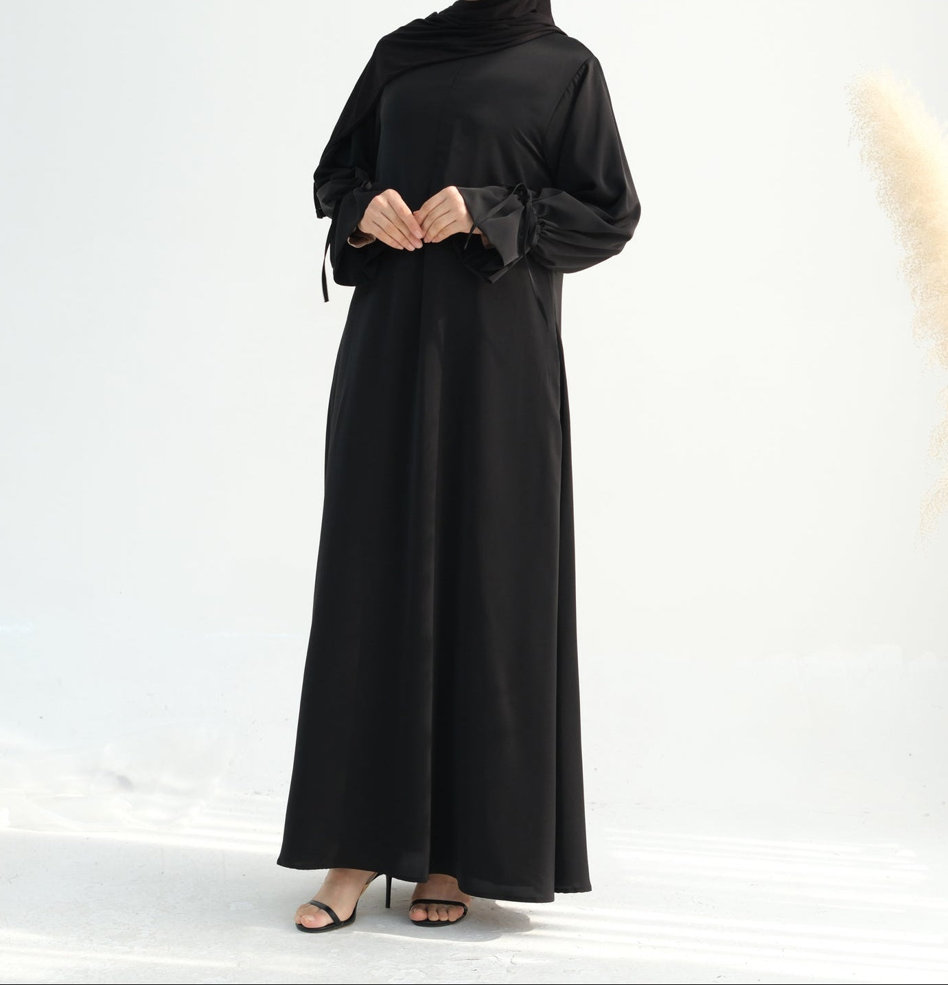Woman wearing a black abaya on a white background