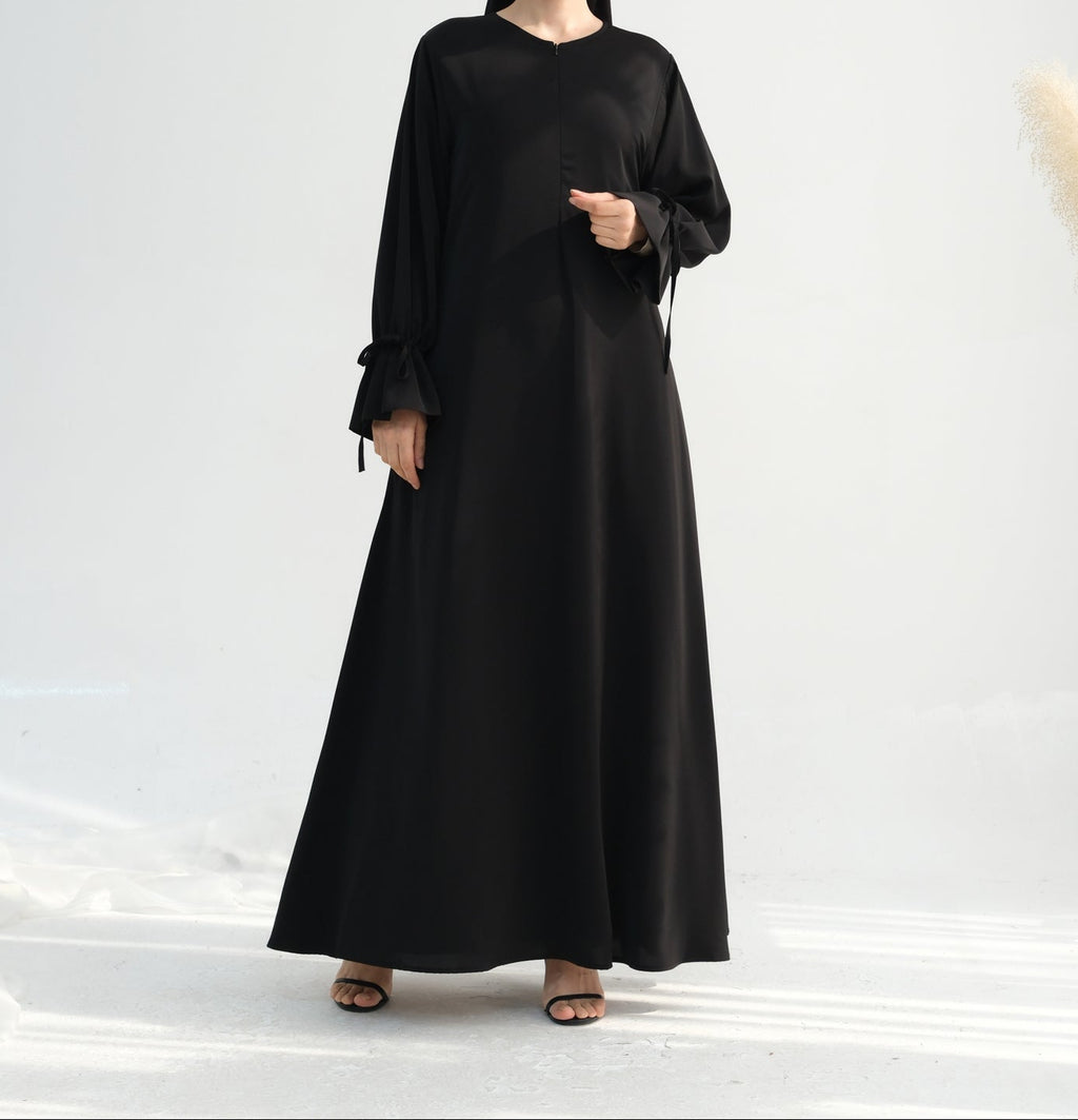 Woman wearing a black abaya on a white background
