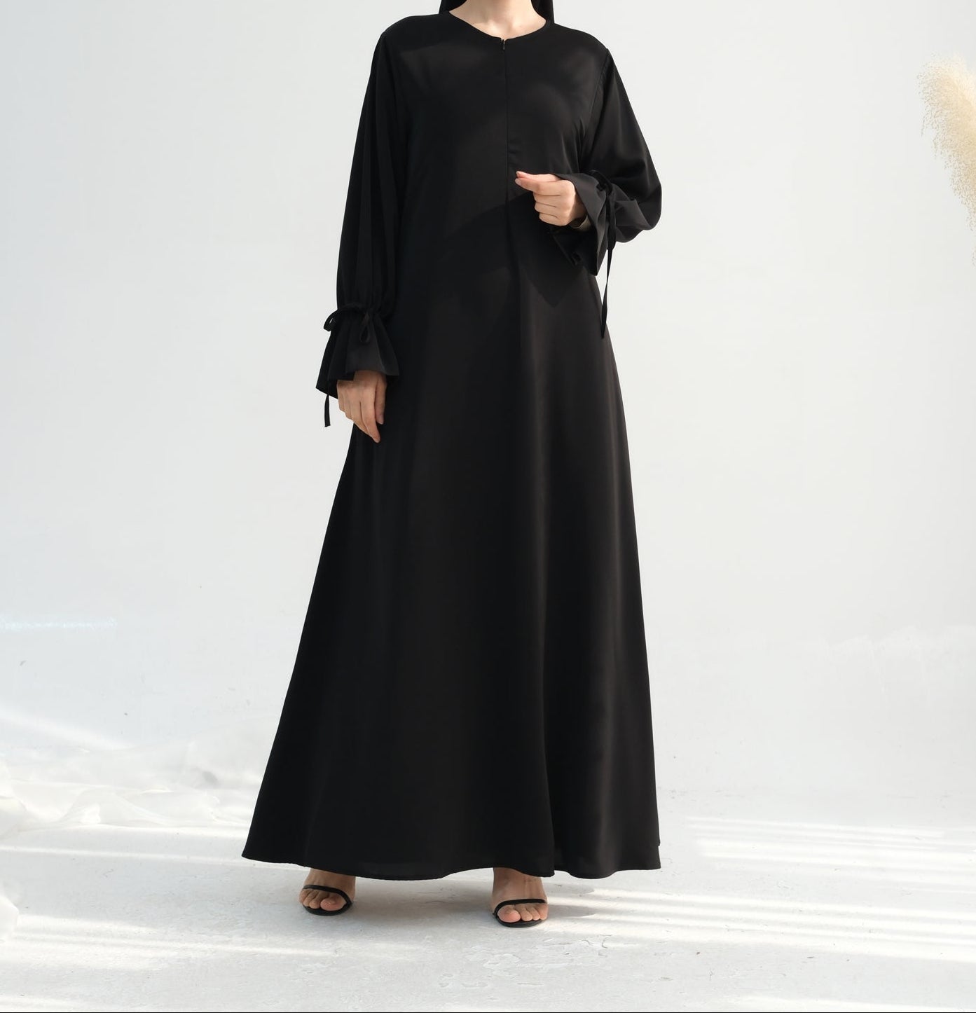 Woman wearing a black abaya on a white background