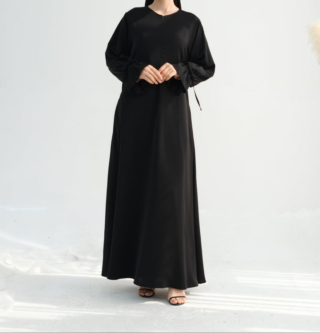 Woman wearing a black abaya on a white background