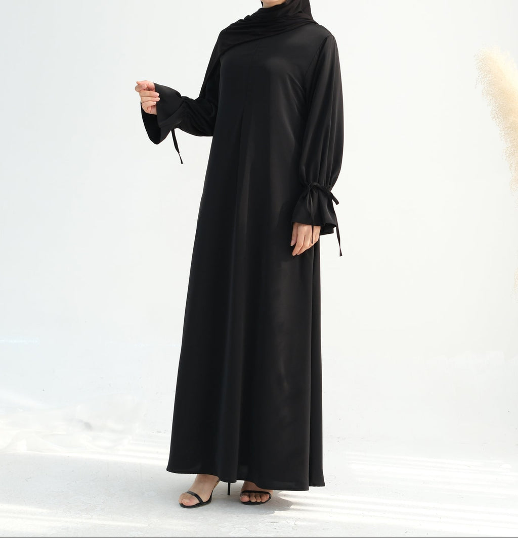 Woman wearing a black abaya on a white background