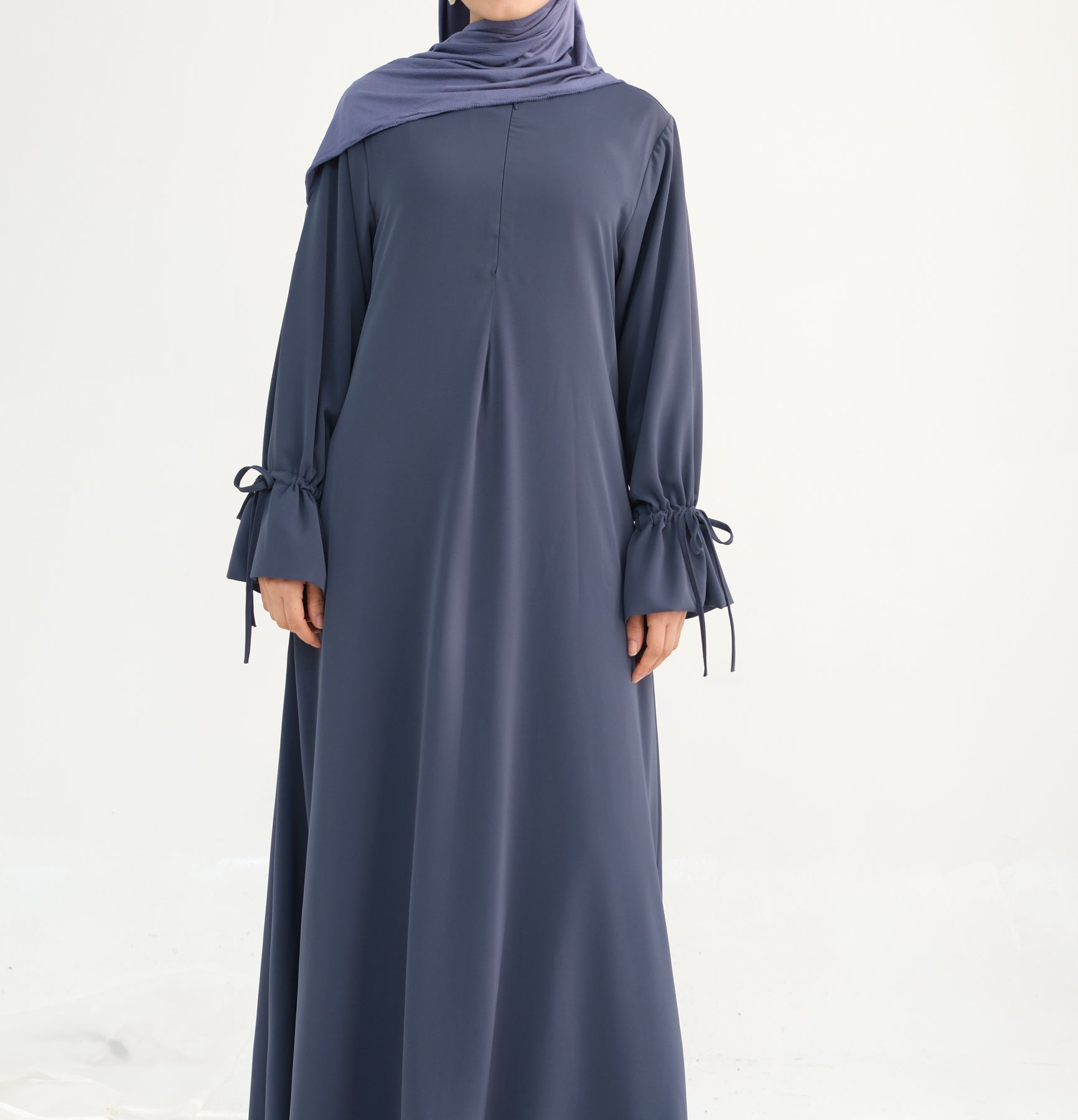 Long dark blue dress with matching hijab on a white background