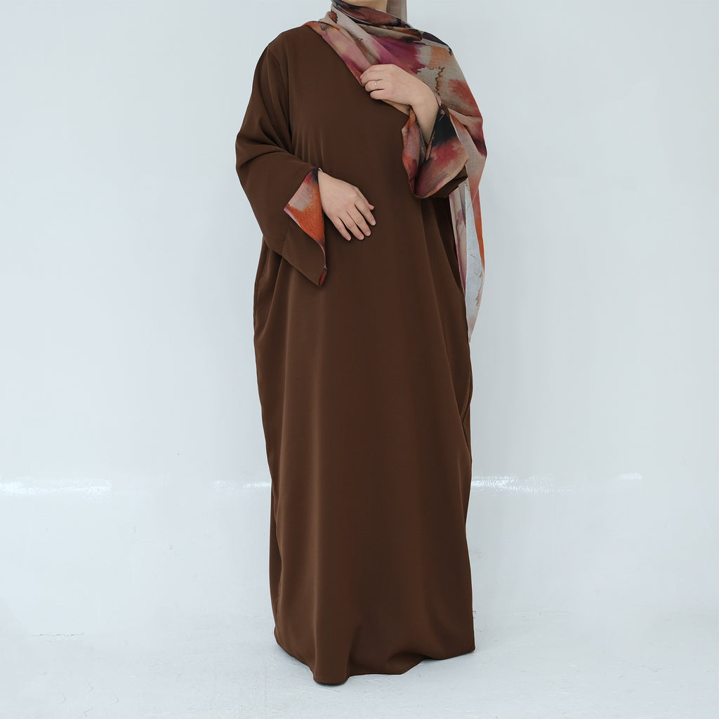 Brown abaya with a patterned shawl on a white background