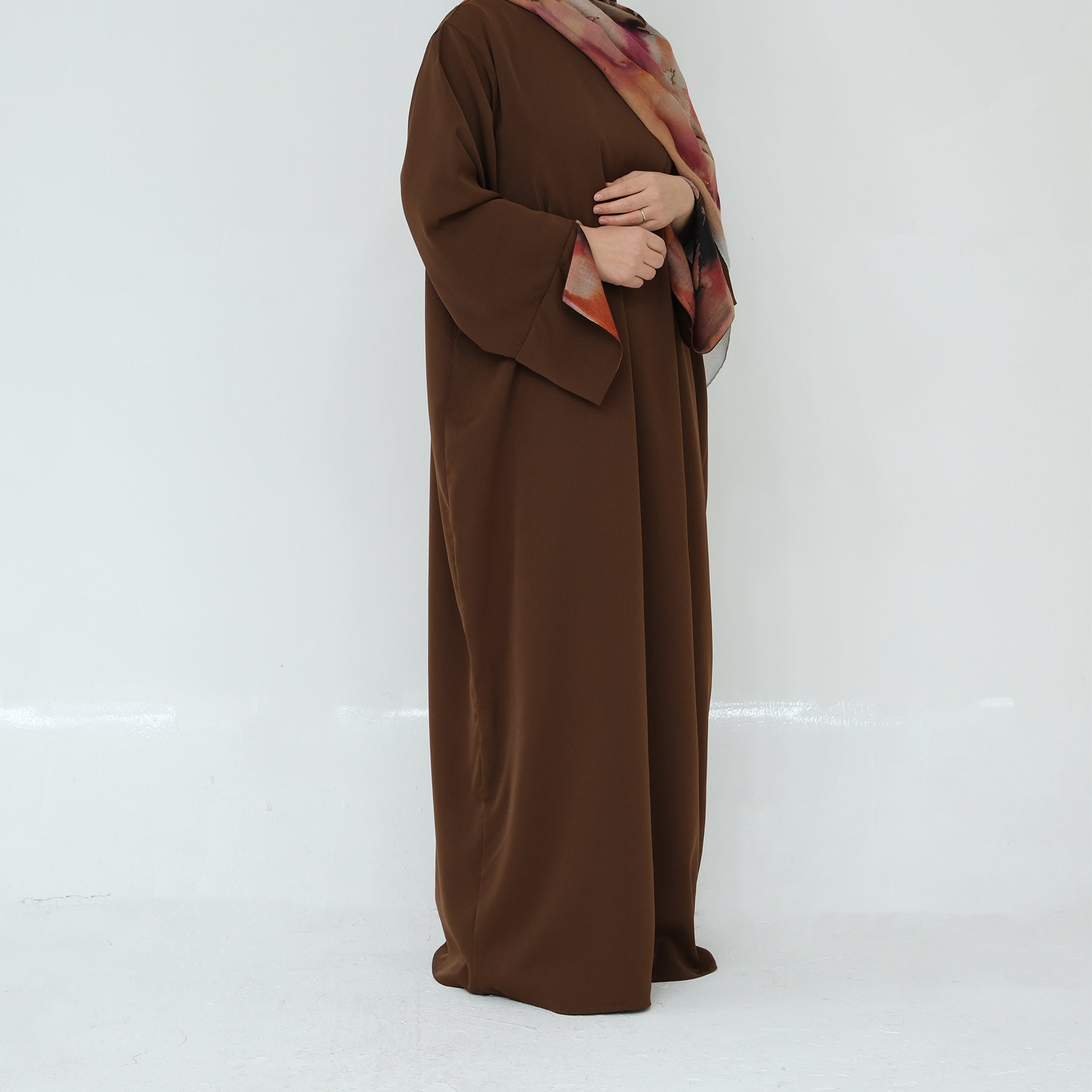 Brown abaya with a colorful scarf on a white background