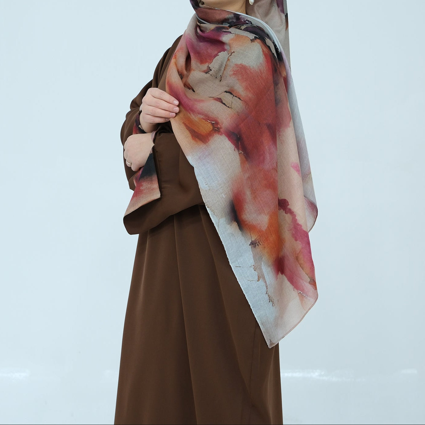 Woman wearing a colorful scarf with abstract design on a light blue background
