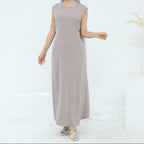 Woman wearing a long beige dress on a white background