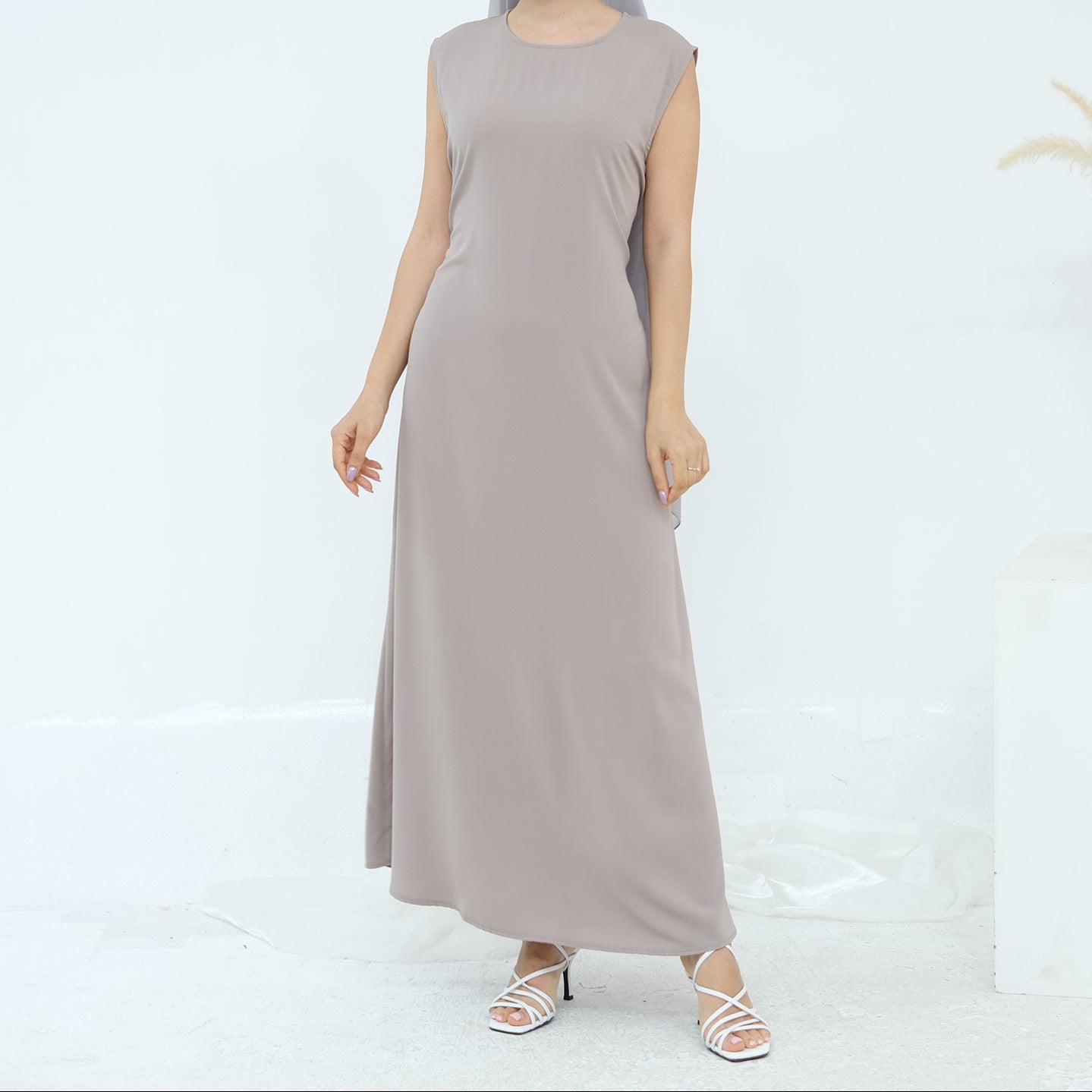 Woman wearing a long gray dress on a white background