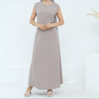 Woman wearing a long beige dress on a white background