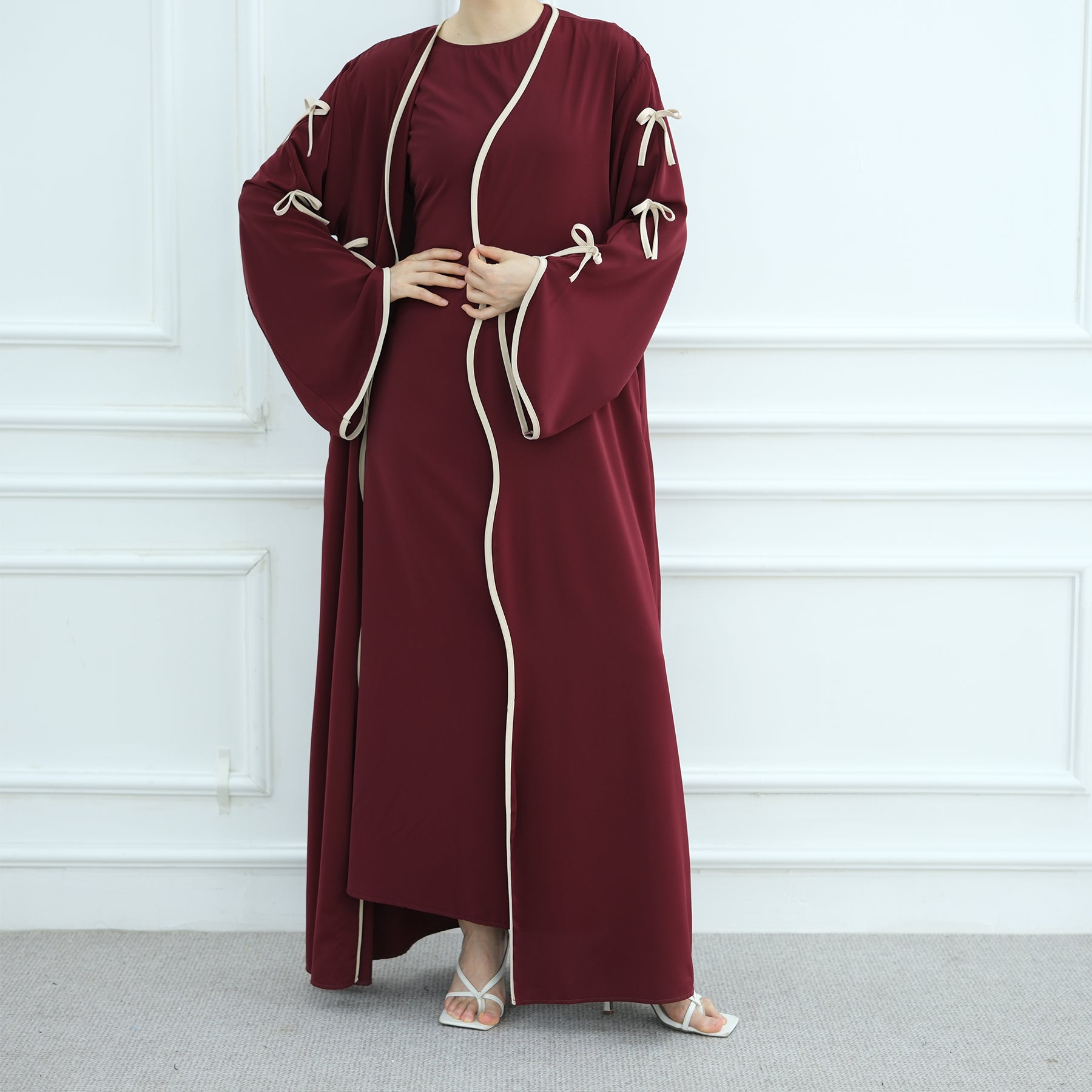 Maroon dress with white trim worn by a person against a white background