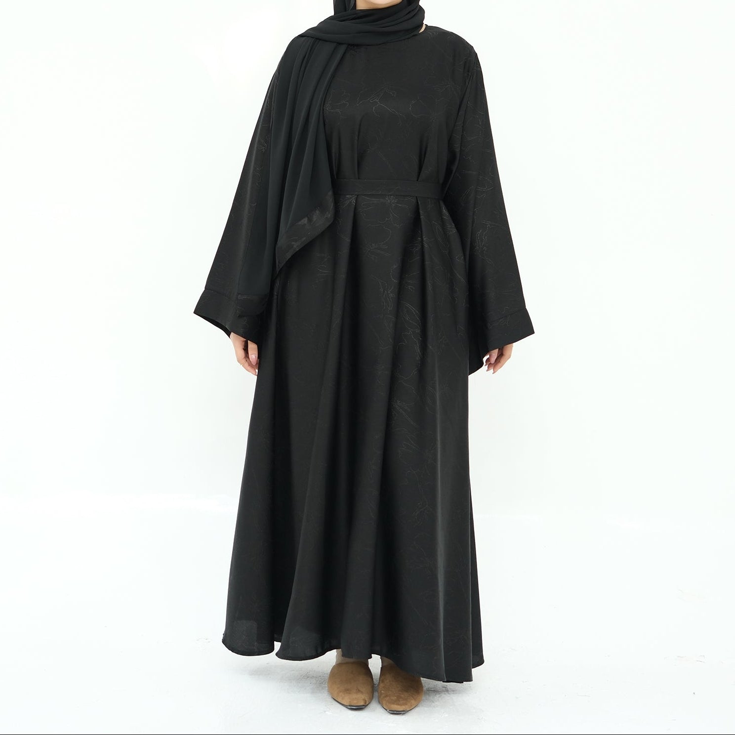 Woman wearing a black abaya on a white background