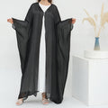 Woman wearing a black abaya over a white dress on a white background LayalAl-FajrAbaya_Noor_GraceBlack1