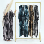 Marbled patterned dresses on a gold clothing rack against a white background