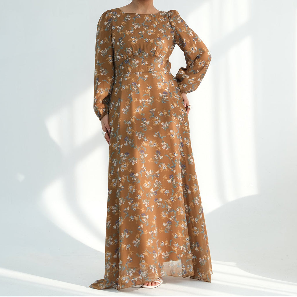 Woman wearing a long, sheer dress with floral pattern on a white background